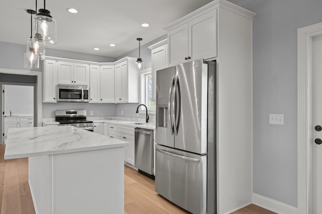 14758 Green View Dr, Elkton, VA 22827 - kitchen featuring appliances with stainless steel finishes, a sink, white cabinets, a center island, and light wood finished floors