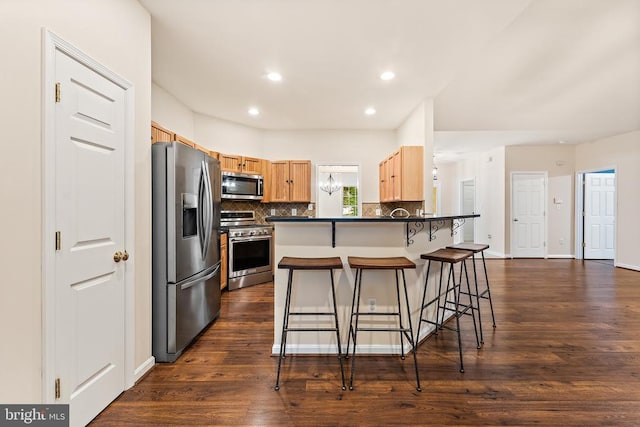10614 Rhoads Dr, Fredericksburg, VA 22407 - kitchen featuring appliances with stainless steel finishes, a kitchen bar, a peninsula, backsplash, and dark countertops