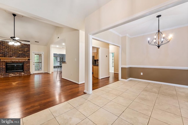 10614 Rhoads Dr, Fredericksburg, VA 22407 - unfurnished dining area with tile patterned flooring, ceiling fan, a chandelier, vaulted ceiling, and a brick fireplace