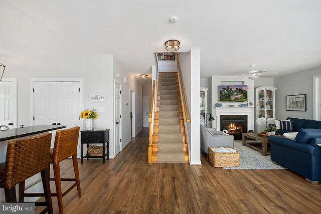 326 Anna Highview, Bumpass, VA 23024 - living room with dark wood-style flooring, a lit fireplace, ceiling fan, stairway, and baseboards