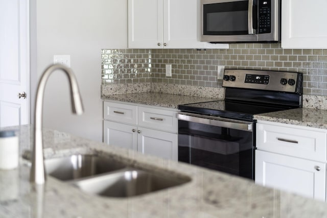 133 Lake View Cir, Waynesboro, VA 22980 - kitchen featuring appliances with stainless steel finishes, backsplash, white cabinets, and light stone countertops