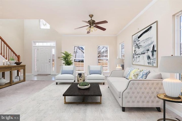  - carpeted living area featuring healthy amount of natural light, stairs, a ceiling fan, and crown molding