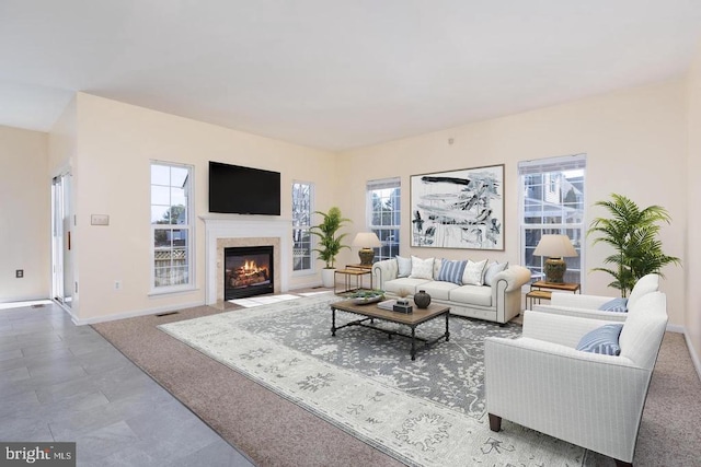  - carpeted living area featuring baseboards and a fireplace with flush hearth