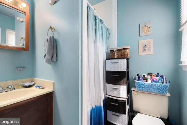 bathroom featuring vanity, toilet, and a shower with curtain