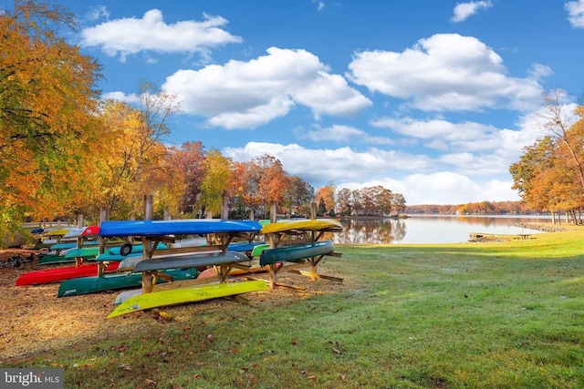view of property's community with a water view and a yard
