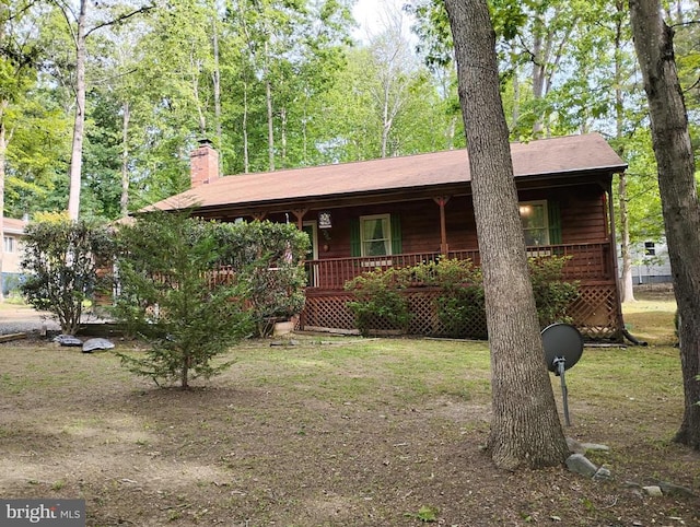view of side of property with a porch and a chimney