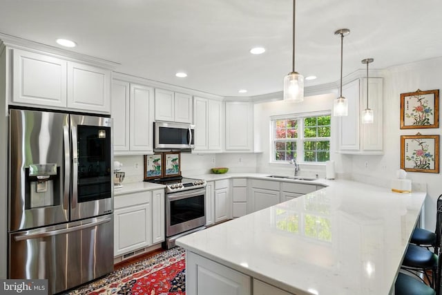 kitchen featuring appliances with stainless steel finishes, a peninsula, a sink, white cabinetry, and recessed lighting