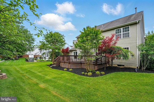 view of green lawn with a wooden deck