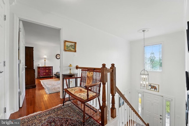 hall with a chandelier, an upstairs landing, and wood-type flooring