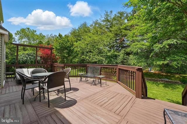 deck featuring outdoor dining area and a yard
