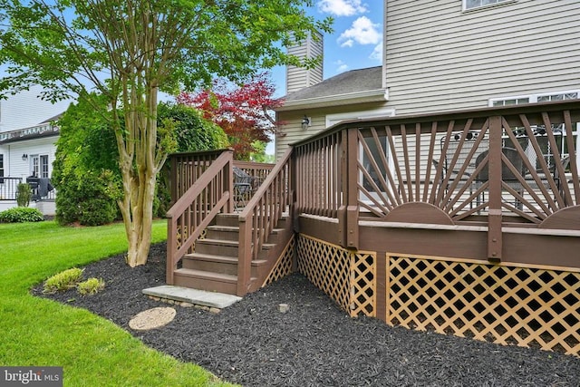 wooden deck with stairway and a lawn