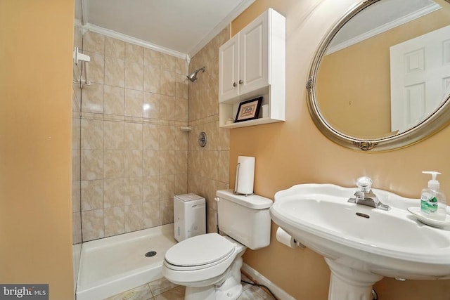 bathroom featuring tiled shower, ornamental molding, toilet, a sink, and tile patterned floors