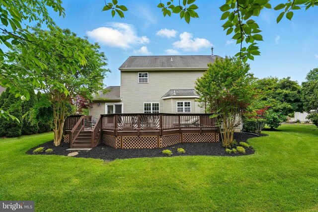 back of property with a yard and a wooden deck