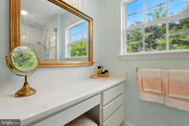 bathroom featuring plenty of natural light, a shower stall, and vanity
