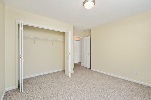 unfurnished bedroom featuring carpet flooring, a closet, and baseboards