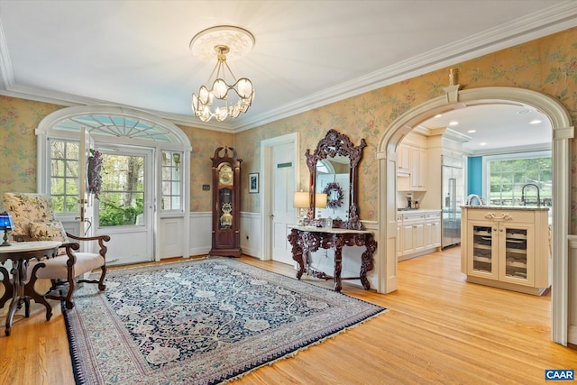 3220 Longdale Furnace Rd, Clifton Forge, VA 24422 - entrance foyer with wallpapered walls, light wood-style flooring, wainscoting, ornamental molding, and a chandelier