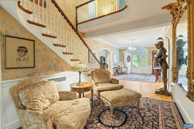 3220 Longdale Furnace Rd, Clifton Forge, VA 24422 - living area featuring wallpapered walls, wood finished floors, arched walkways, wainscoting, and crown molding