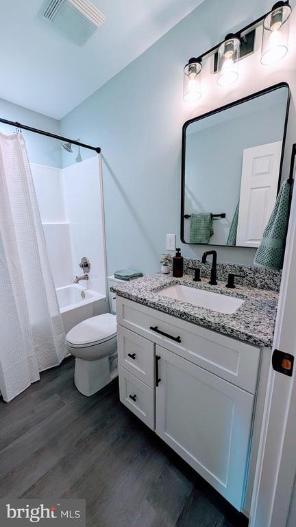176 Tussing Ln, Rochelle, VA 22738 - full bath featuring wood finished floors, vanity, toilet, and shower / bathtub combination with curtain