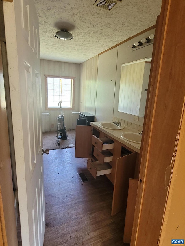 bathroom featuring a textured ceiling, visible vents, and a sink