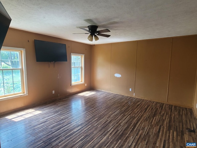 unfurnished living room with ceiling fan, a textured ceiling, wood finished floors, and a healthy amount of sunlight