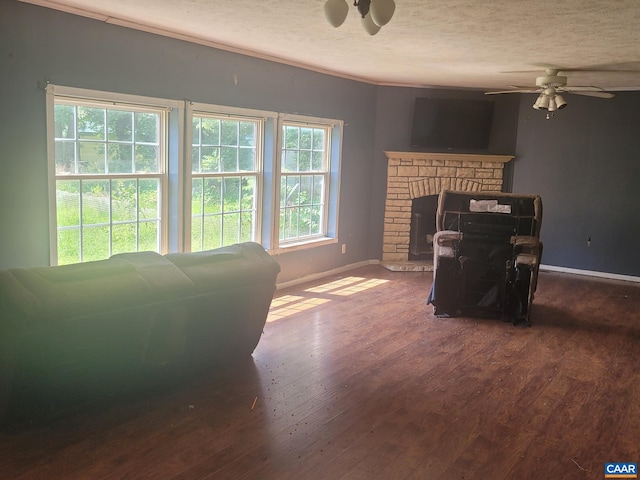 living room featuring a wealth of natural light, wood finished floors, baseboards, and ceiling fan