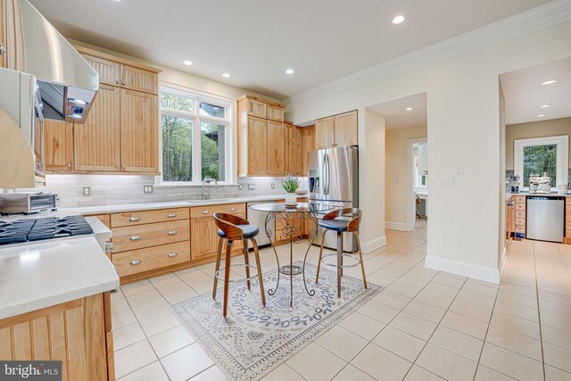 87 River Bend Rd E, Fredericksburg, VA 22407 - kitchen featuring appliances with stainless steel finishes, wall chimney range hood, light brown cabinetry, ornamental molding, and backsplash
