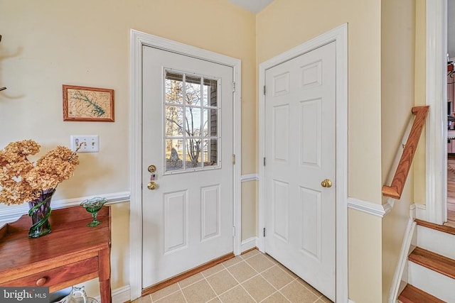 entryway with light tile patterned floors and baseboards
