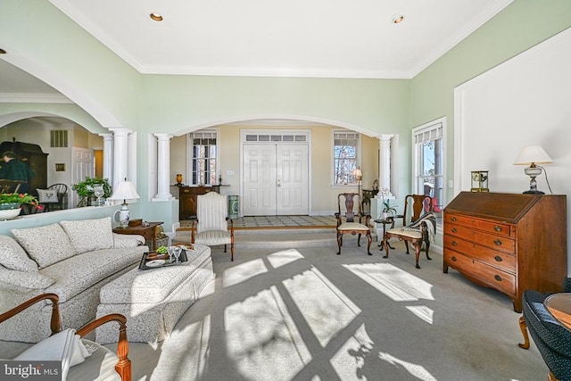 living room with ornamental molding, carpet flooring, arched walkways, and ornate columns