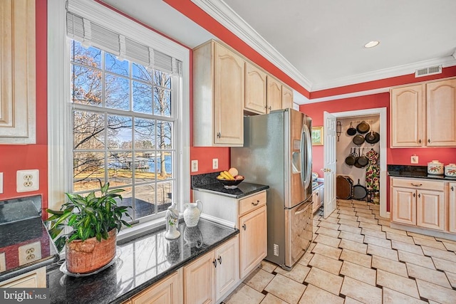 kitchen with dark stone counters, ornamental molding, visible vents, light brown cabinets, and stainless steel fridge with ice dispenser