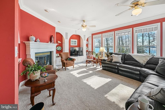 living room featuring carpet, ornamental molding, ceiling fan, and plenty of natural light