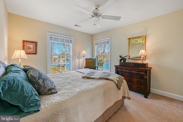 carpeted bedroom featuring ceiling fan, access to outside, baseboards, and visible vents