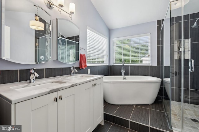 6215 Hot Spring Ln, Fredericksburg, VA 22407 - bathroom with a shower stall, vaulted ceiling, a freestanding tub, double vanity, and wainscoting