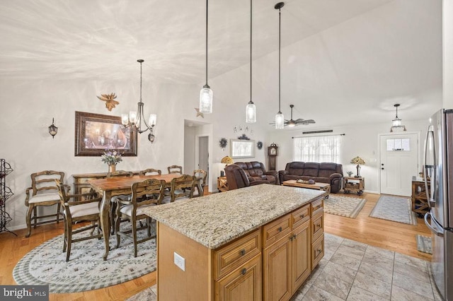53 Arthur Ln, Luray, VA 22835 - kitchen featuring freestanding refrigerator, light stone counters, a chandelier, decorative light fixtures, and high vaulted ceiling