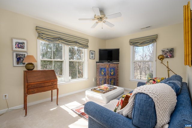 living area featuring baseboards, visible vents, ceiling fan, and carpet flooring