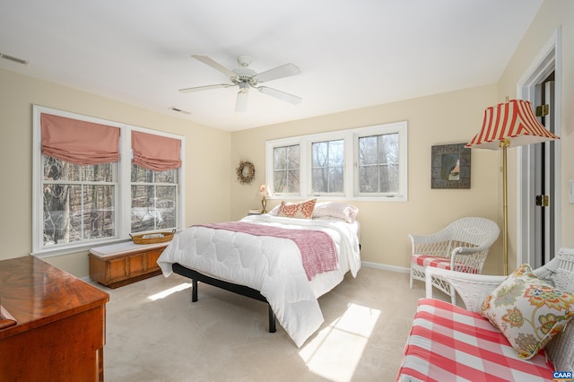 bedroom featuring a ceiling fan, light colored carpet, visible vents, and baseboards