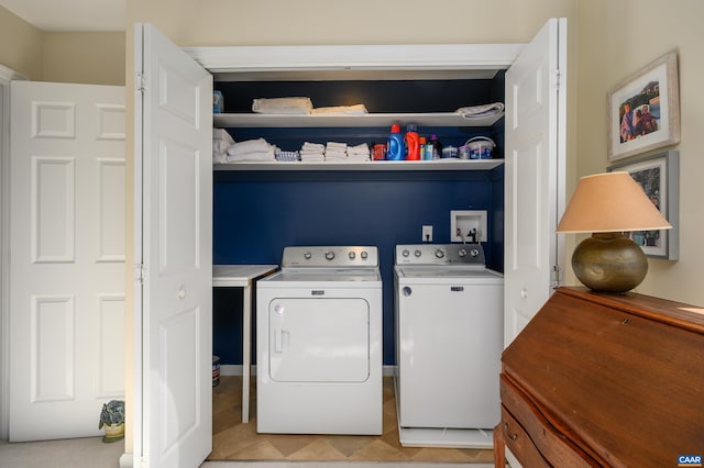 washroom featuring laundry area, light tile patterned floors, and washing machine and clothes dryer