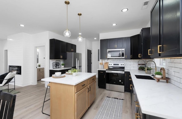 9 Walnut St, Fishersville, VA 22939 - kitchen featuring stainless steel appliances, a sink, light wood-type flooring, a breakfast bar area, and recessed lighting