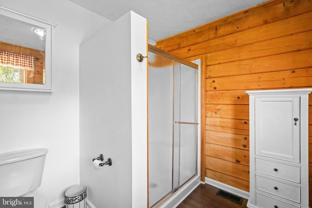 248 Wintergreen Dr, Luray, VA 22835 - full bath featuring a stall shower, toilet, visible vents, wood walls, and wood finished floors