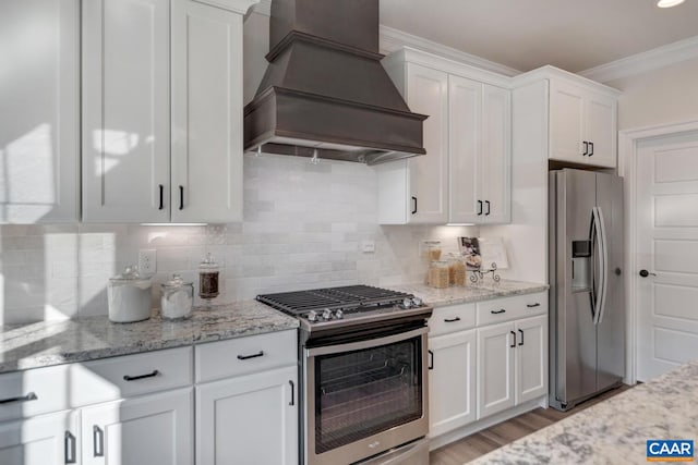 33 Ashlin Cv, Charlottesville, VA 22901 - kitchen with custom range hood, white cabinets, appliances with stainless steel finishes, tasteful backsplash, and ornamental molding