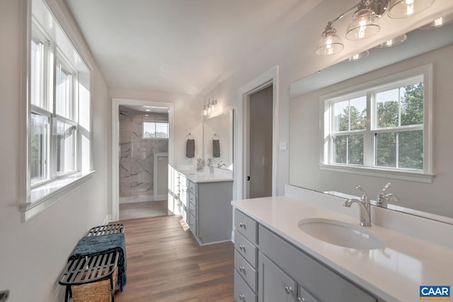 33 Ashlin Cv, Charlottesville, VA 22901 - bathroom with wood finished floors, a tile shower, two vanities, and a sink