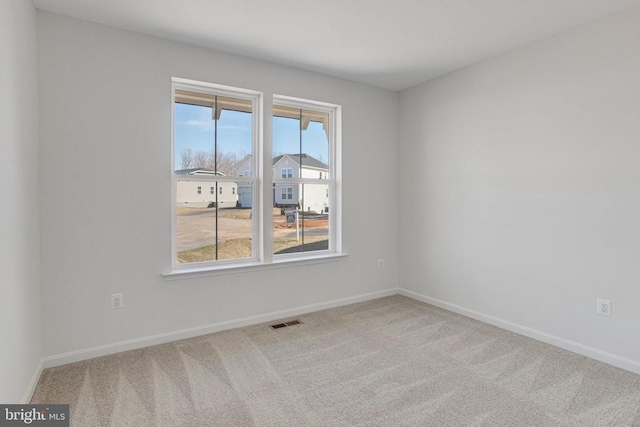 carpeted empty room featuring baseboards