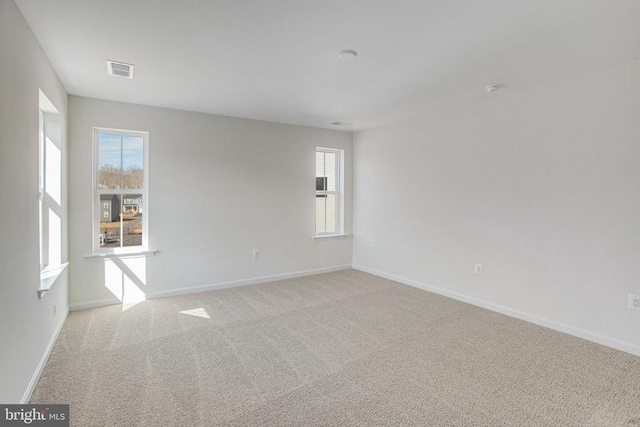 carpeted empty room featuring plenty of natural light and baseboards