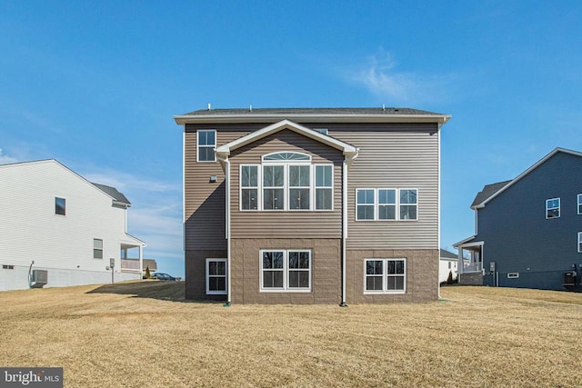 back of house featuring a yard and central AC unit