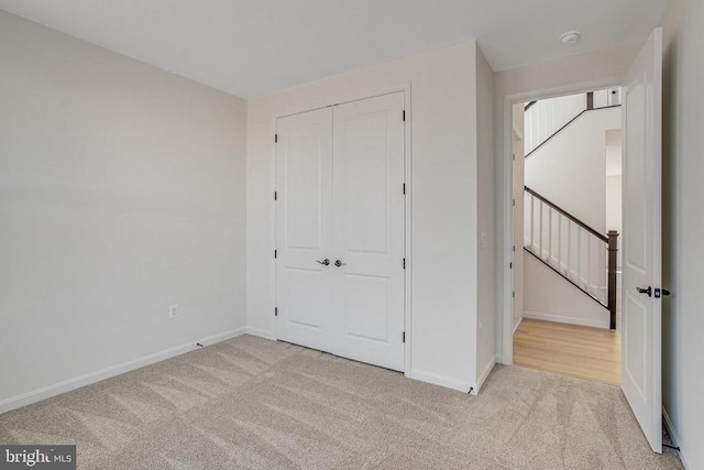 unfurnished bedroom with carpet, baseboards, and a closet