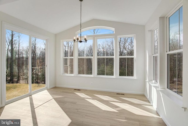 unfurnished sunroom featuring a chandelier, wood finished floors, vaulted ceiling, and baseboards