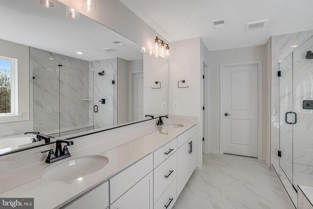 bathroom featuring marble finish floors, a marble finish shower, and double vanity