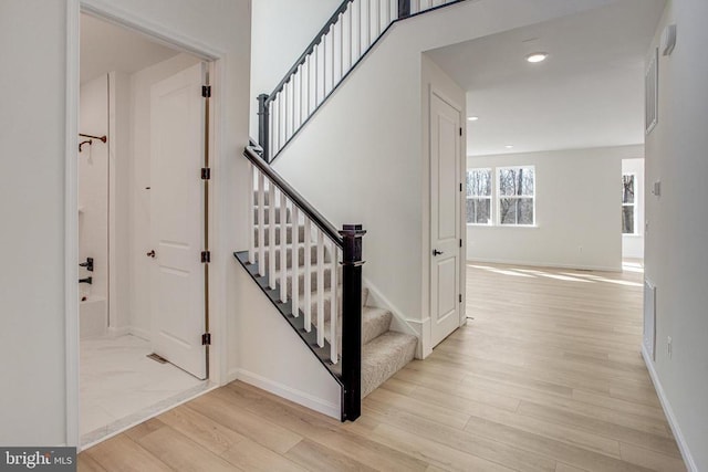 stairs featuring wood finished floors, recessed lighting, and baseboards