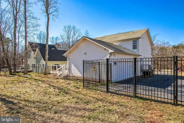 back of house with a yard, a garage, fence, and a gate