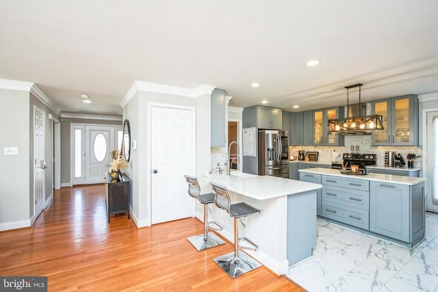 kitchen with a peninsula, ornamental molding, recessed lighting, wall chimney exhaust hood, and appliances with stainless steel finishes
