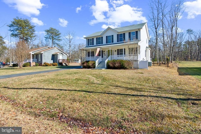 colonial inspired home featuring covered porch, aphalt driveway, and a front lawn